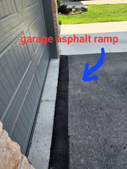 Garage asphalt ramp with labeled concrete foundation crack and blue arrow pointing to ramp edge